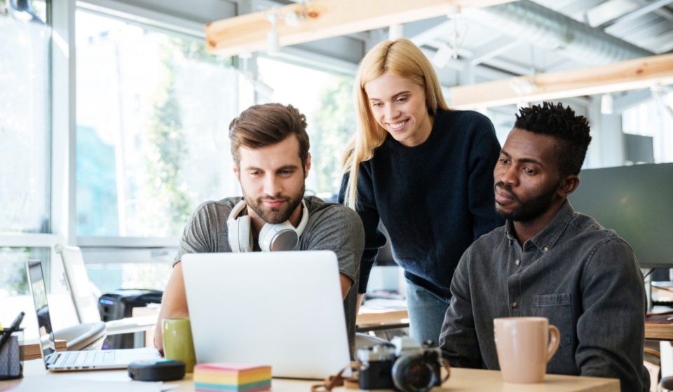 happy-colleagues-sitting-in-office-coworking-PHYA6TG